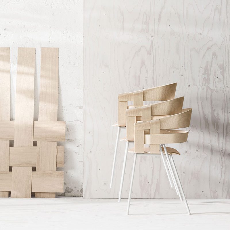 Stacked wooden chairs in minimalist setting.