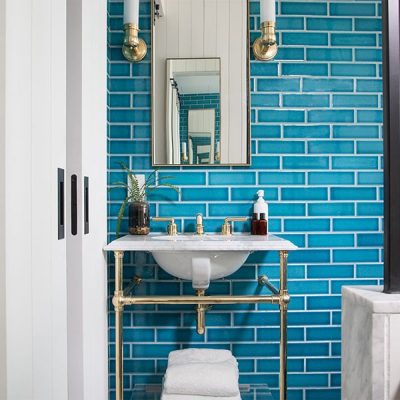 Bathroom with blue tiled wall and sink.