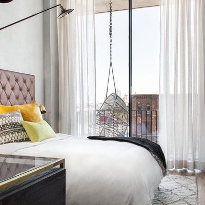 Modern bedroom with swing chair by window.