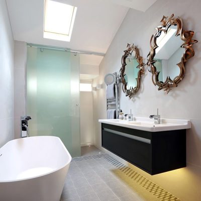 Modern bathroom with bathtub and ornate mirrors.