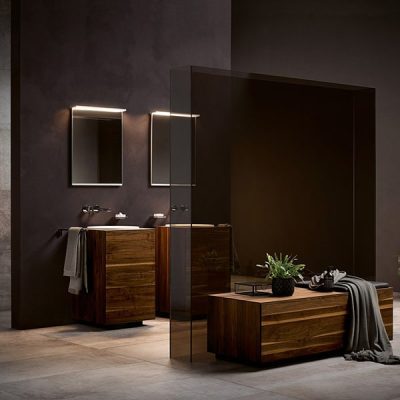 Modern bathroom with wooden vanity and plants.