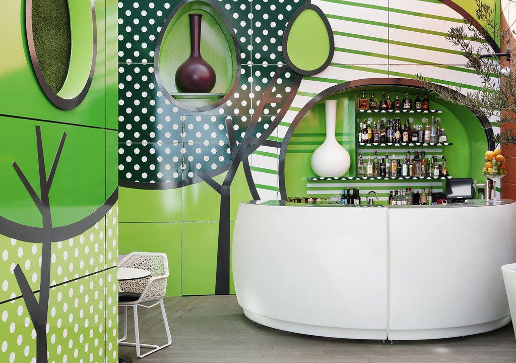 Modern bar with green geometric wall design.