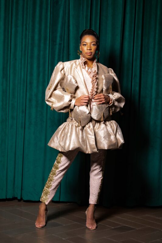 Fashionable woman in elaborate gold outfit.