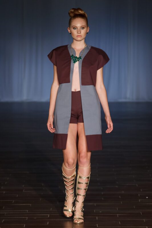 Model wearing modern fashion on runway.