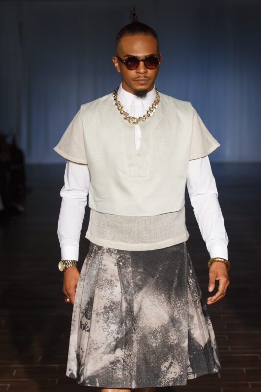 Male model in modern fashion outfit walking.