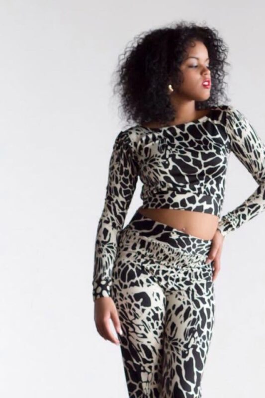Woman in patterned top and pants outfit.