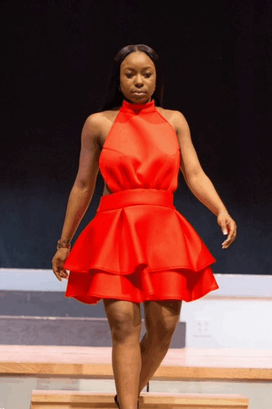 Woman in red dress walking on stage.