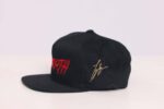 Black cap with red and gold embroidery.