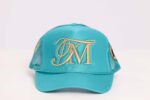 Teal baseball cap with embroidered initials.