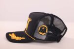 Black mesh cap with gold embroidery.
