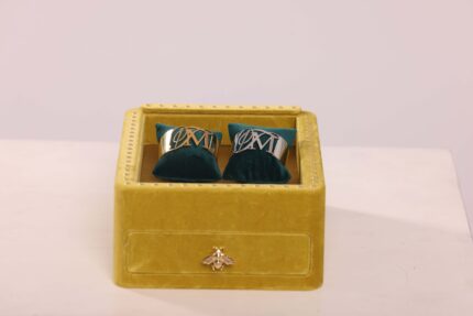 Gold cufflinks in a yellow velvet box.