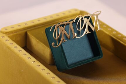 Gold initials "M M" on velvet box.