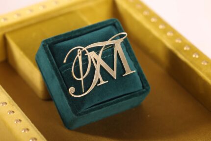 Monogrammed brooch in velvet jewelry box.