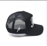 Black mesh baseball cap with white signature and text design.