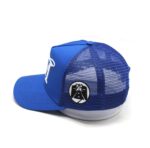 Blue mesh trucker cap with a round logo patch on the side.